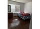 Simple bedroom with wood floors, twin bed, dresser and window at 8113 Maple Stream Ln, Indianapolis, IN 46217
