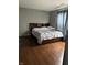 Spacious bedroom with wood floors, a large bed and patterned curtains at 8113 Maple Stream Ln, Indianapolis, IN 46217
