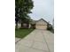 Charming single-story home with a well-manicured lawn and a two-car attached garage, featuring brick and siding accents at 8113 Maple Stream Ln, Indianapolis, IN 46217