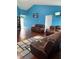 Spacious living room with vaulted ceilings, hardwood floors, comfortable leather seating, and bright blue walls at 8113 Maple Stream Ln, Indianapolis, IN 46217
