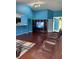 Bright, open living area with hardwood floors, leather sofas, and an entertainment center against vibrant blue walls at 8113 Maple Stream Ln, Indianapolis, IN 46217