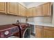 Laundry room featuring wooden cabinets, countertops, and a set of red front load washer and dryer at 8115 Cole Wood Blvd, Indianapolis, IN 46239