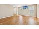 Spacious living room with hardwood floors, neutral walls, bright windows, and a door leading to other parts of the home at 8115 Cole Wood Blvd, Indianapolis, IN 46239