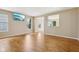An empty living room featuring wood floors, recessed lighting, and bright windows, creating a warm and inviting space at 8115 Cole Wood Blvd, Indianapolis, IN 46239