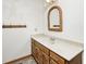 Bathroom with a wooden vanity, wicker-framed mirror, and a light fixture above at 817 S Jefferson St, Brownsburg, IN 46112