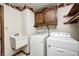 Laundry room with washer, dryer, a utility sink, and overhead cabinets at 817 S Jefferson St, Brownsburg, IN 46112