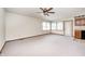 Spacious living room with neutral carpet, ceiling fan, and a large window letting in natural light at 817 S Jefferson St, Brownsburg, IN 46112