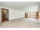 Expansive living area with neutral carpet, white walls, and natural wood trim details at 817 S Jefferson St, Brownsburg, IN 46112
