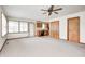 Bright living room featuring neutral carpet, ceiling fan, and direct access to the adjacent kitchen and dining area at 817 S Jefferson St, Brownsburg, IN 46112