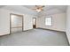 Bright main bedroom showcasing plush carpet, a ceiling fan, a large closet, and an ensuite bathroom at 817 S Jefferson St, Brownsburg, IN 46112