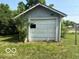 Exterior garage with an overgrown yard at 822 W 7Th St, Muncie, IN 47302