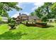 A beautifully landscaped backyard featuring a lush lawn, mature trees, and swimming pool at 8534 Helmsman Cir, Indianapolis, IN 46256