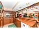 Finished basement bar area with custom wood cabinets, shelving, sink, and refrigerator for entertaining at 8534 Helmsman Cir, Indianapolis, IN 46256