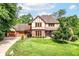 Charming Tudor-style home with a well-manicured lawn, mature trees, and attached garage at 8534 Helmsman Cir, Indianapolis, IN 46256