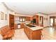 Well-lit kitchen with island cooktop, wood cabinetry, and tile flooring at 8534 Helmsman Cir, Indianapolis, IN 46256
