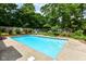 A serene in-ground pool surrounded by lush landscaping and concrete patios at 8534 Helmsman Cir, Indianapolis, IN 46256