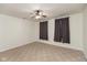 Bedroom with neutral carpet, ceiling fan, and windows adorned with dark curtains for a cozy ambiance at 905 Buchanan St, Indianapolis, IN 46203