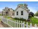 Charming cottage-style home featuring a classic white picket fence and well-maintained lawn and landscaping at 905 Buchanan St, Indianapolis, IN 46203