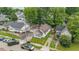 An aerial view shows the house nestled among lush trees, surrounded by neighboring homes in a residential area at 1011 W 7Th St, Anderson, IN 46016