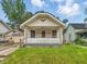 Charming one-story home with a cozy front porch and a well-maintained front yard at 1011 W 7Th St, Anderson, IN 46016