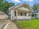 Lovely one-story home featuring a welcoming front porch and adjacent detached garage at 1011 W 7Th St, Anderson, IN 46016