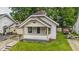 Charming home featuring a covered front porch, brick chimney, and a compact yard needing some attention at 1011 W 7Th St, Anderson, IN 46016