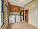 Well-equipped laundry area with vinyl floor, washer, dryer, and upper cabinets for storage at 1011 W 7Th St, Anderson, IN 46016