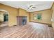 A yellow-painted living room features a brick fireplace and hardwood floors and an overhead fan at 1011 W 7Th St, Anderson, IN 46016