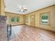 A yellow-painted living room offers a brick fireplace, a ceiling fan, and windows at 1011 W 7Th St, Anderson, IN 46016