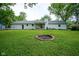 Large backyard with firepit, mature trees, and covered patio ideal for outdoor entertaining and relaxation at 1015 Fox Hill Dr, Indianapolis, IN 46228