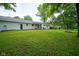 Spacious backyard featuring well-maintained lawn, mature trees, and covered patio perfect for outdoor enjoyment at 1015 Fox Hill Dr, Indianapolis, IN 46228