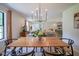 Open-concept dining area flows into a living space, illuminated by modern chandelier, perfect for entertaining at 1015 Fox Hill Dr, Indianapolis, IN 46228