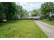 Attractive brick home featuring a lush front lawn, mature trees, and long driveway leading to a two car garage at 1015 Fox Hill Dr, Indianapolis, IN 46228