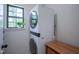 Efficient laundry area with stacked washer and dryer, maximizing space, complemented by natural light from the window at 1015 Fox Hill Dr, Indianapolis, IN 46228