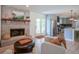 Comfortable living room featuring a brick fireplace, seamless access to a modern kitchen and backyard at 1015 Fox Hill Dr, Indianapolis, IN 46228