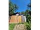 Old shed, surrounded by trees, shows signs of disrepair with patched siding and boarded up walls at 1031 Blaine Ave, Indianapolis, IN 46221