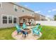 Landscaped backyard featuring a pergola, fire pit with chairs, and grilling area at 10334 Deercrest Ln, Indianapolis, IN 46239