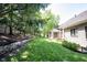 Expansive backyard features a lush lawn, mature trees, and a stone retaining wall at 10707 Burning Ridge Ln, Fishers, IN 46037