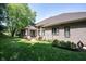 Brick home with sprawling backyard, lush lawn, mature trees, and patio seating area at 10707 Burning Ridge Ln, Fishers, IN 46037