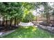 Lush backyard with mature trees, hammock, stone retaining wall, and wooded perimeter at 10707 Burning Ridge Ln, Fishers, IN 46037