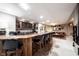 Basement bar with wooden counter and stools, wine rack, and leather sofa in background at 10707 Burning Ridge Ln, Fishers, IN 46037