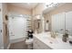 Updated bathroom features tile flooring, white vanity, brushed gold faucet and white tiled shower at 10707 Burning Ridge Ln, Fishers, IN 46037