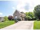 Two-story home showcasing a three-car garage, brick exterior, and a well-maintained lawn with mature trees at 10707 Burning Ridge Ln, Fishers, IN 46037