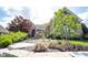 Stunning brick home with a meticulously landscaped front yard, showcasing vibrant plants and tasteful rock accents at 10707 Burning Ridge Ln, Fishers, IN 46037