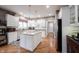 Well-lit kitchen featuring white cabinetry, an island, granite countertops, and hardwood floors at 10707 Burning Ridge Ln, Fishers, IN 46037