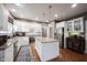 Well-lit kitchen features granite countertops, stainless steel appliances, and white cabinets with hardwood floors at 10707 Burning Ridge Ln, Fishers, IN 46037