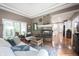 Elegant living room with a fireplace, a comfortable sofa, and natural light streaming through the windows at 10707 Burning Ridge Ln, Fishers, IN 46037