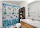 Charming bathroom with turtle-themed shower curtain and a wooden storage cabinet at 1571 N Creekwater Pass, Greenfield, IN 46140