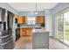 Well-lit kitchen with stainless steel appliances, wooden cabinets, and sliding glass door to yard at 1571 N Creekwater Pass, Greenfield, IN 46140