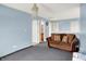 Cozy living room with blue walls, carpet, a brown sofa, and decorative lighting at 1571 N Creekwater Pass, Greenfield, IN 46140